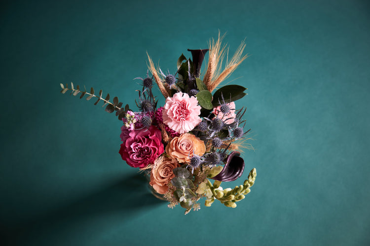 Mixed dried and fresh flower bouquet with pink roses, thistle, wheat, and greenery