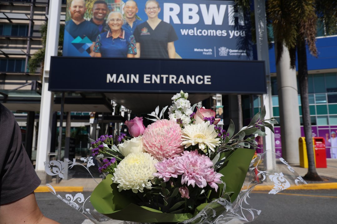 Spring Hill Florist Staff holding a pink and white bouquet outside Royal Brisbane and Women's Hospital Florist entrance
