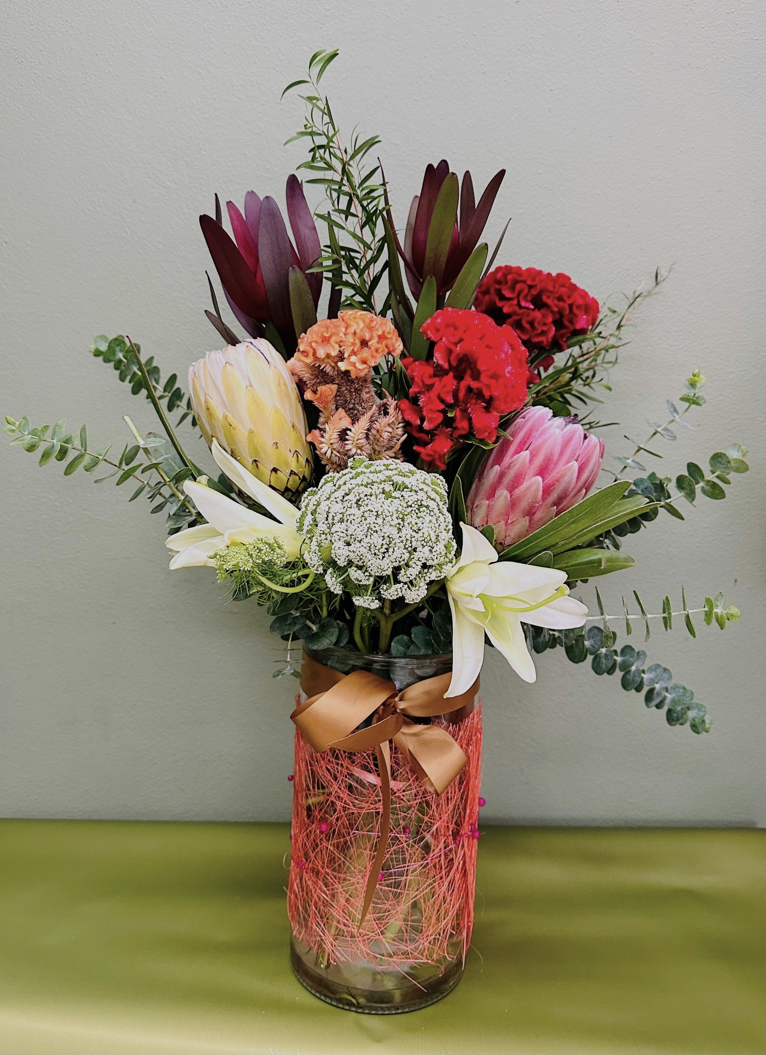 Native flower arrangement displayed in a decorative vase with seasonal Australian flowers.