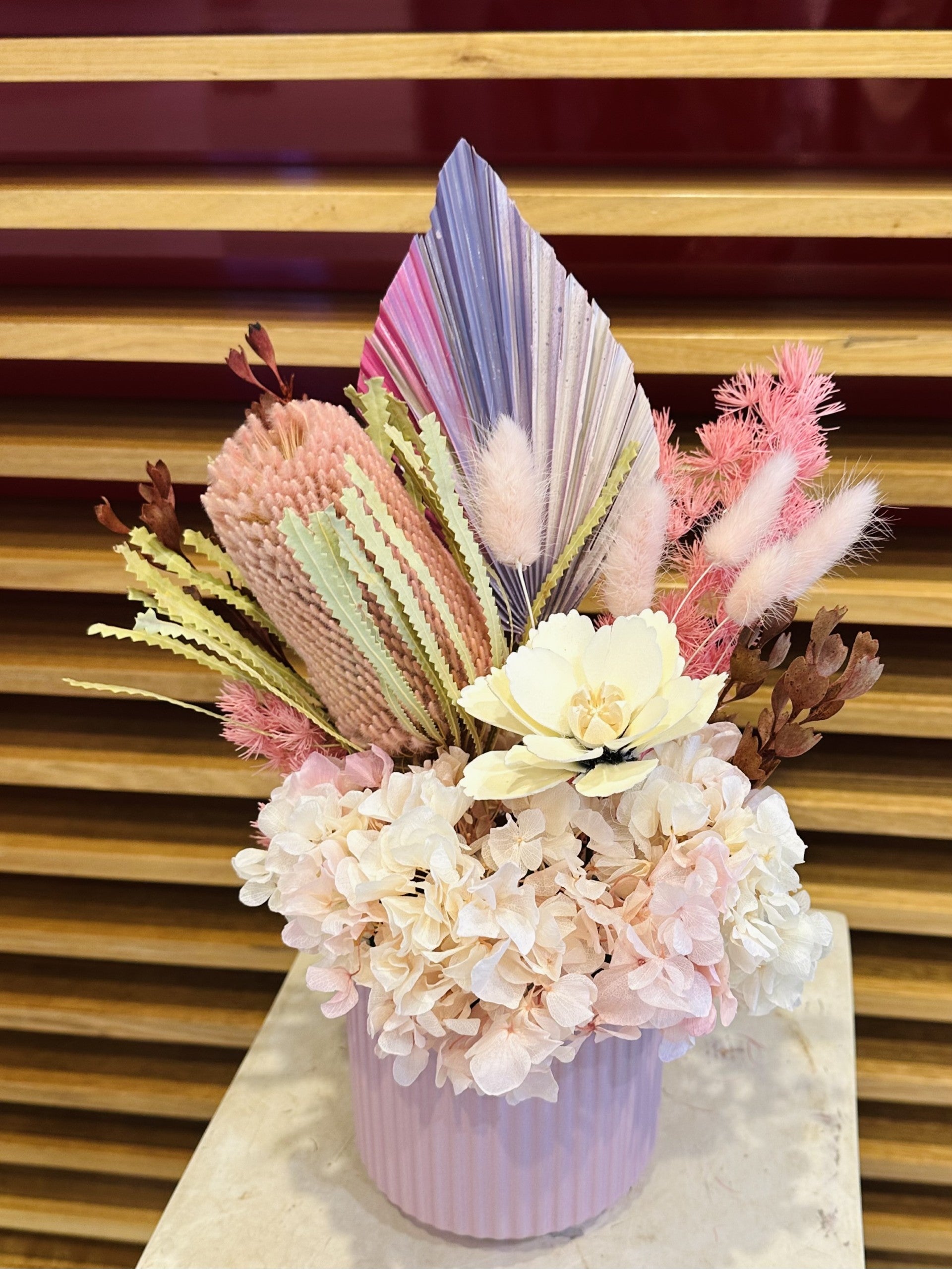 Pink and cream dried flower arrangement in a pastel pink vase